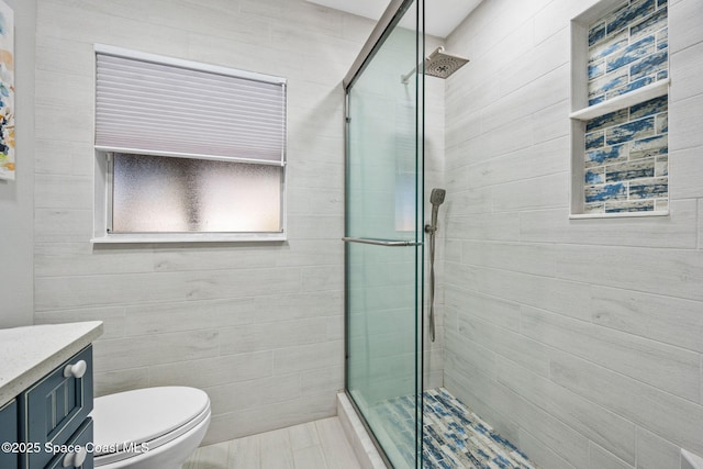 bathroom featuring vanity, toilet, and an enclosed shower