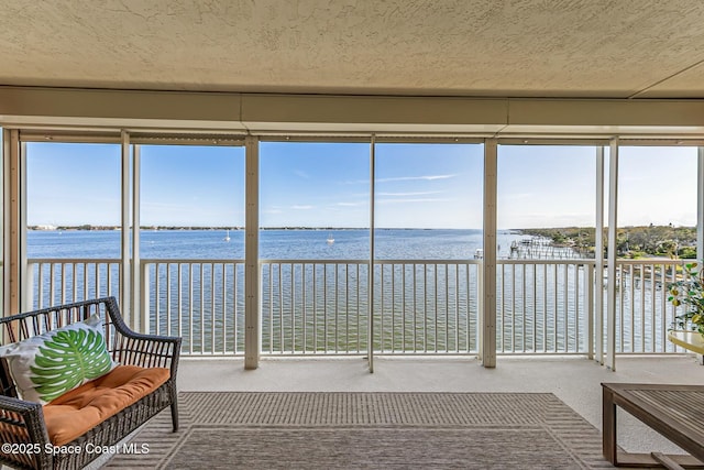 unfurnished sunroom featuring a water view