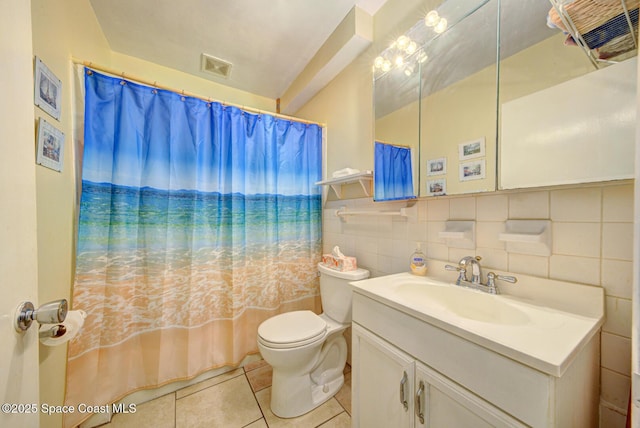 bathroom featuring tile walls, vanity, tile patterned floors, and toilet