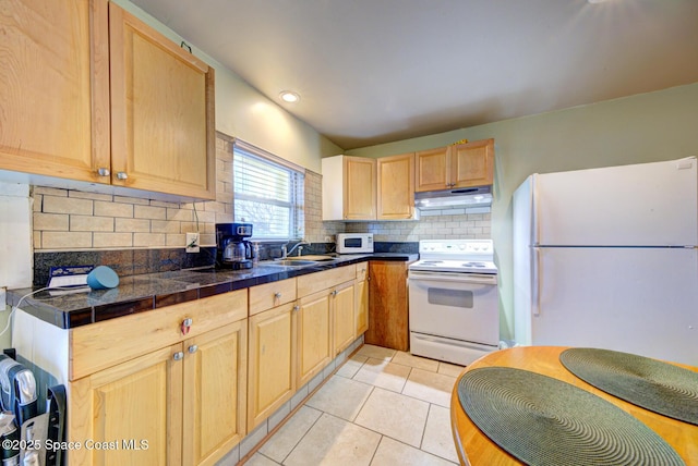 kitchen with light brown cabinetry, sink, white appliances, and light tile patterned floors