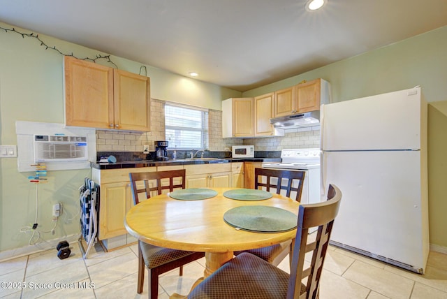 kitchen with white appliances, a wall mounted air conditioner, and light brown cabinets