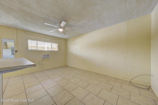 empty room featuring light tile patterned floors, a textured ceiling, a wall unit AC, and ceiling fan