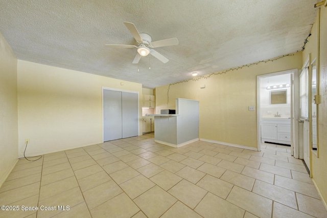 empty room with light tile patterned flooring, a textured ceiling, and ceiling fan