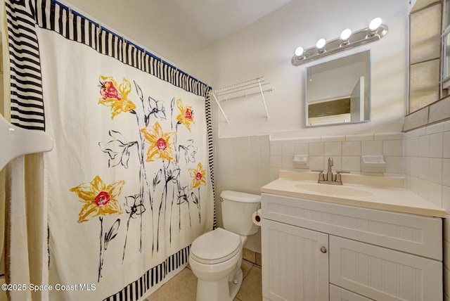 bathroom featuring curtained shower, tile walls, tile patterned flooring, vanity, and toilet