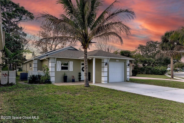 view of front of home with a garage and a yard