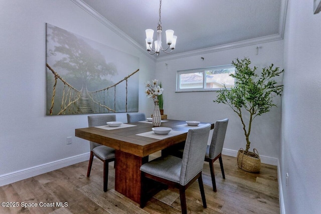 dining space featuring hardwood / wood-style flooring, ornamental molding, and a chandelier