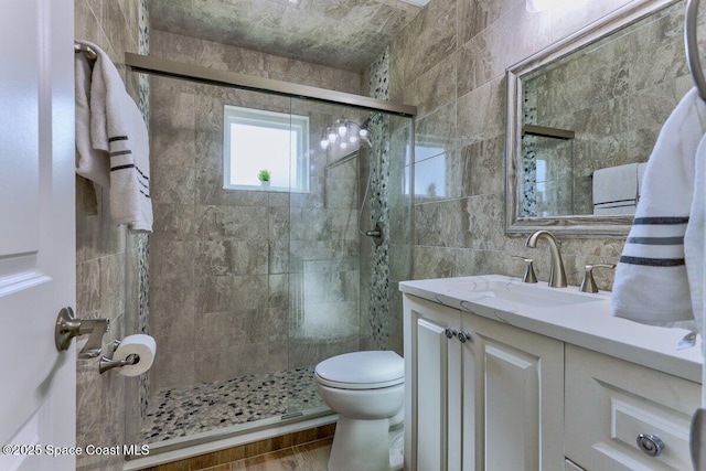 bathroom with tile walls, decorative backsplash, vanity, an enclosed shower, and toilet