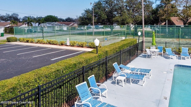 view of swimming pool with tennis court