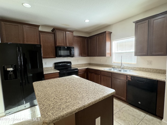 kitchen featuring sink, dark brown cabinets, black appliances, and a center island