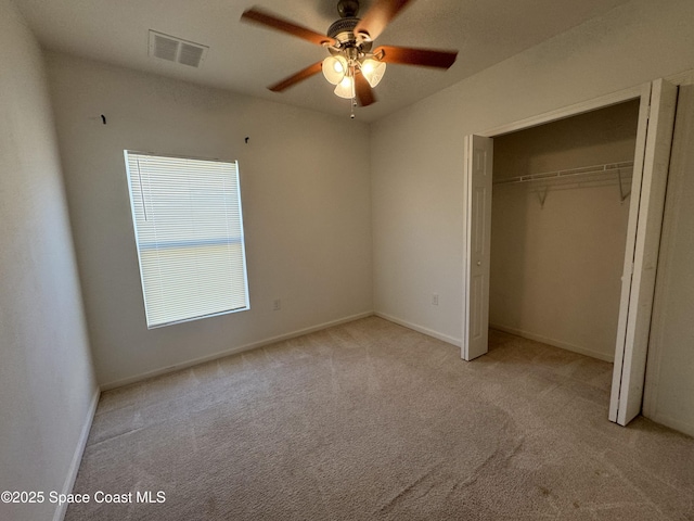 unfurnished bedroom with ceiling fan, light carpet, and a closet