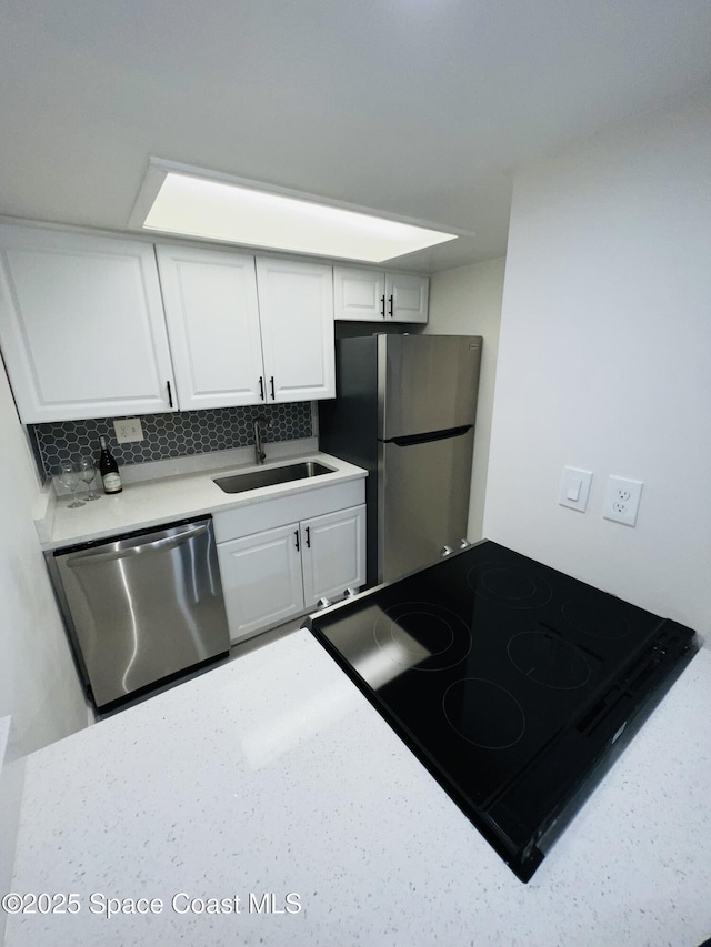 kitchen with tasteful backsplash, stainless steel appliances, sink, and white cabinets