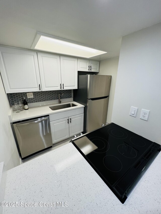 kitchen with white cabinetry, appliances with stainless steel finishes, sink, and tasteful backsplash