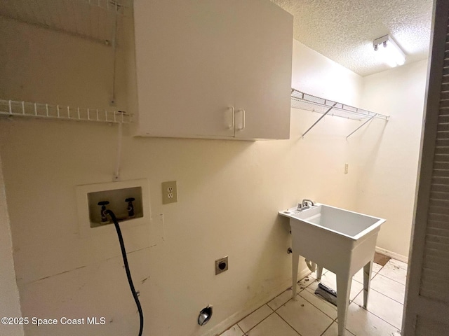 laundry area with light tile patterned flooring, cabinets, washer hookup, electric dryer hookup, and a textured ceiling