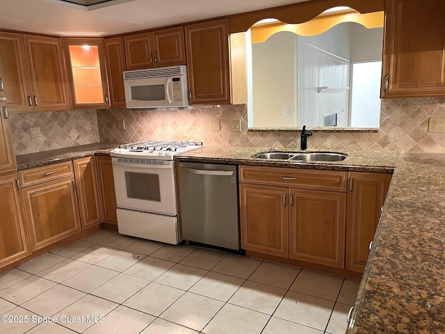 kitchen with light tile patterned flooring, sink, white appliances, and decorative backsplash