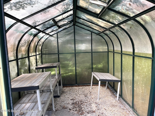 unfurnished sunroom featuring vaulted ceiling