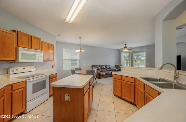 kitchen with pendant lighting, sink, white appliances, light tile patterned floors, and a center island