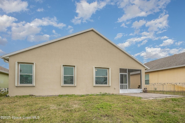 back of property with a yard and a patio area