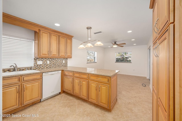 kitchen with sink, dishwasher, backsplash, decorative light fixtures, and kitchen peninsula