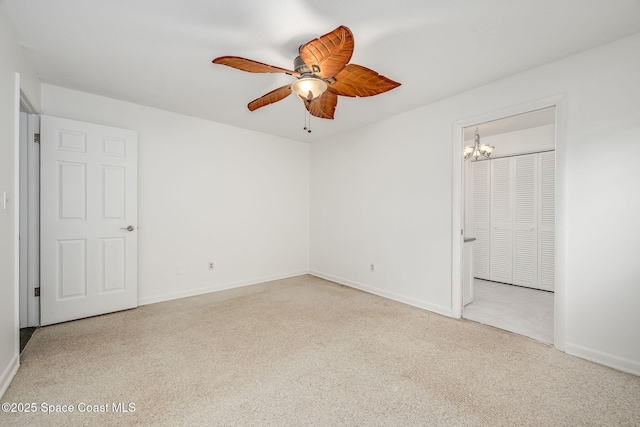 empty room featuring ceiling fan with notable chandelier