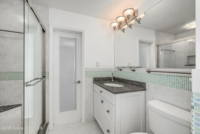 bathroom featuring toilet, an enclosed shower, a chandelier, tile walls, and vanity