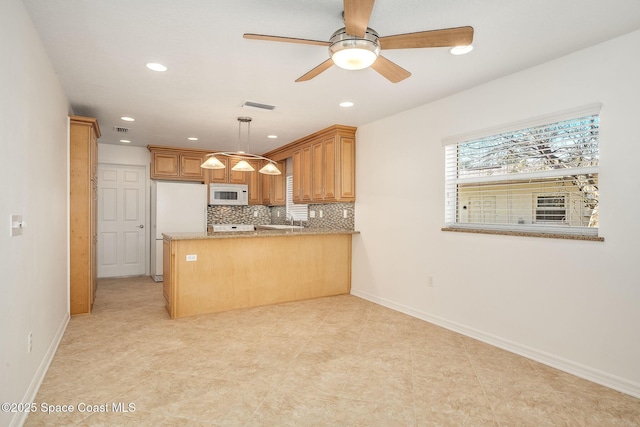 kitchen featuring white appliances, hanging light fixtures, kitchen peninsula, ceiling fan, and backsplash