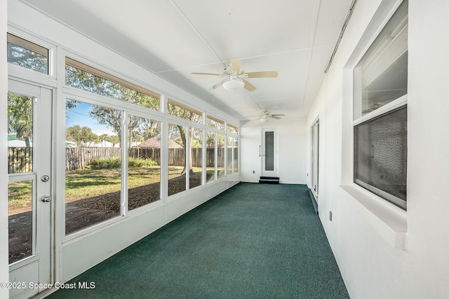 unfurnished sunroom featuring a healthy amount of sunlight and ceiling fan