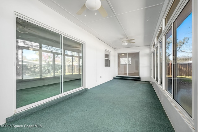 unfurnished sunroom with ceiling fan