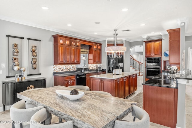 kitchen with sink, double oven, backsplash, hanging light fixtures, and a kitchen island