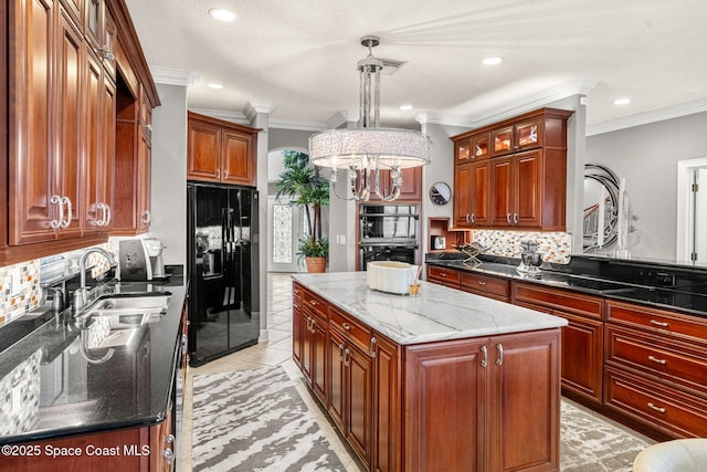 kitchen featuring sink, hanging light fixtures, black appliances, a kitchen island, and dark stone counters