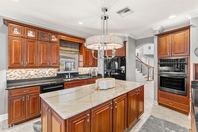 kitchen featuring pendant lighting, a kitchen island, dark stone counters, and black fridge