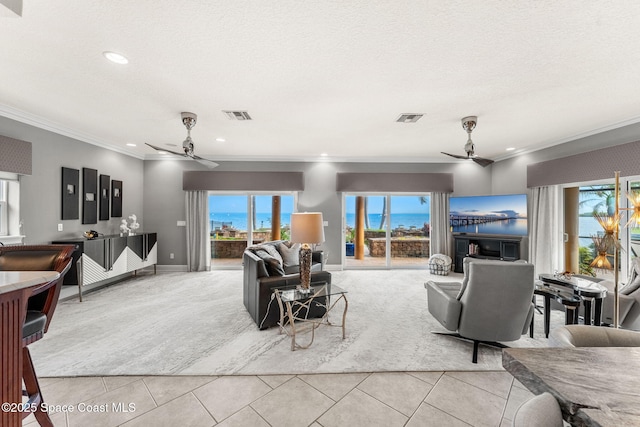 tiled living room featuring ornamental molding, a wealth of natural light, and ceiling fan