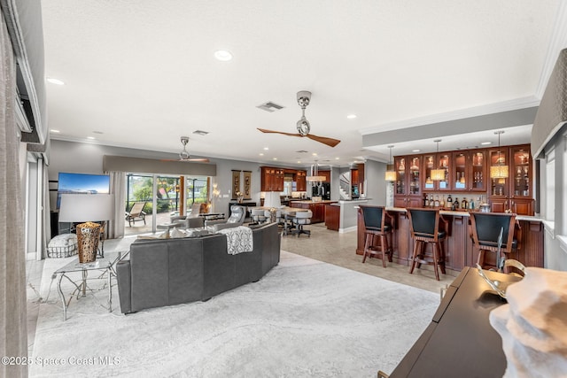 living room featuring ornamental molding, indoor bar, and ceiling fan