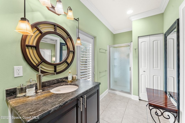 bathroom featuring vanity, crown molding, a shower with door, and tile patterned floors