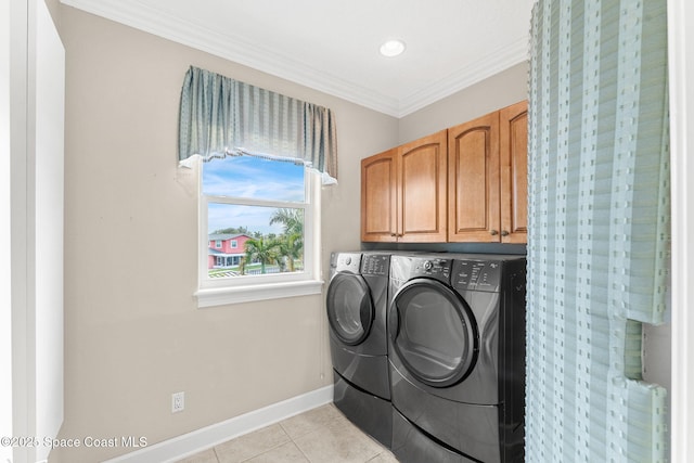 laundry room with crown molding, cabinets, washer and clothes dryer, and light tile patterned floors