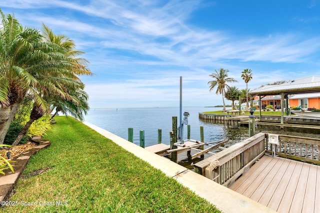 dock area with a water view and a yard