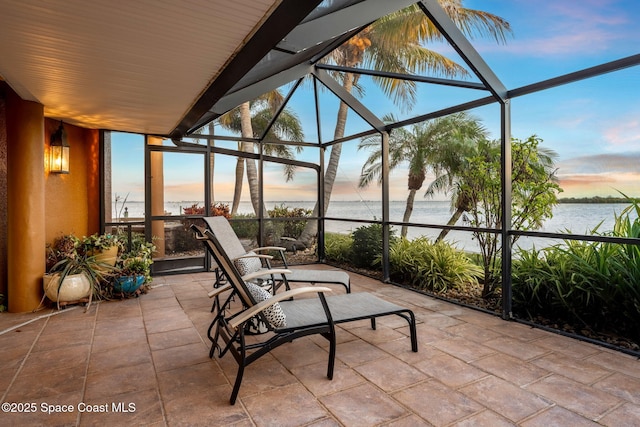 patio terrace at dusk with a water view and a lanai