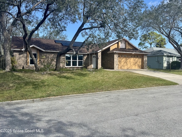 view of front of property with a garage, a front yard, and solar panels