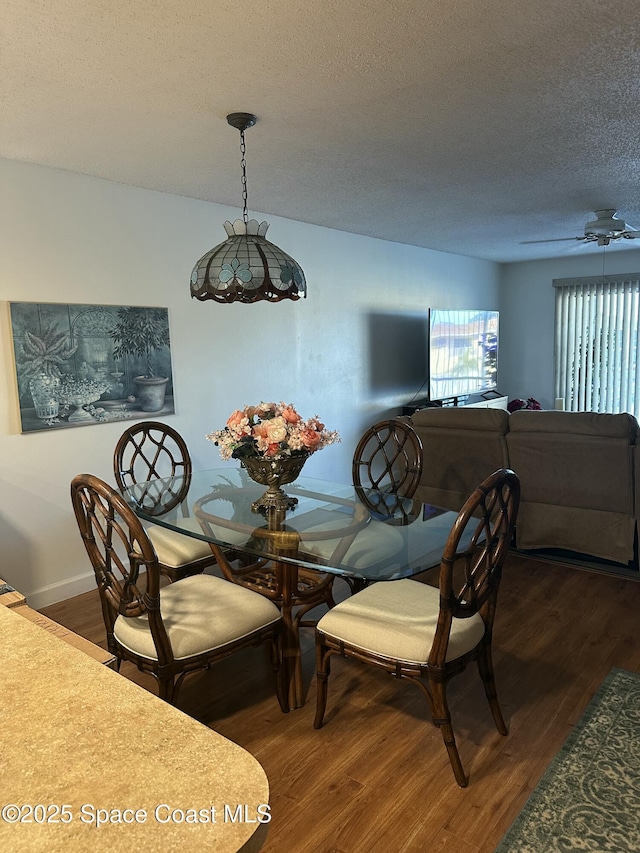 dining space with dark hardwood / wood-style floors and a textured ceiling