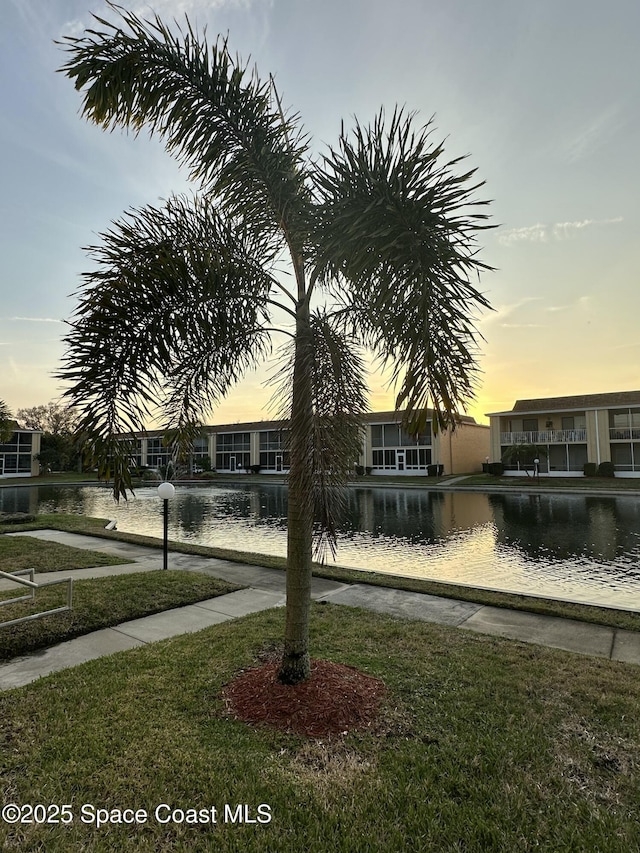 exterior space featuring a water view and a lawn