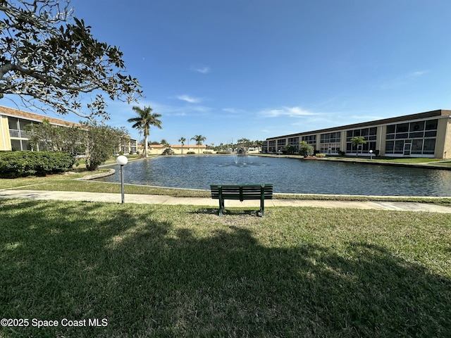 surrounding community with a water view and a yard