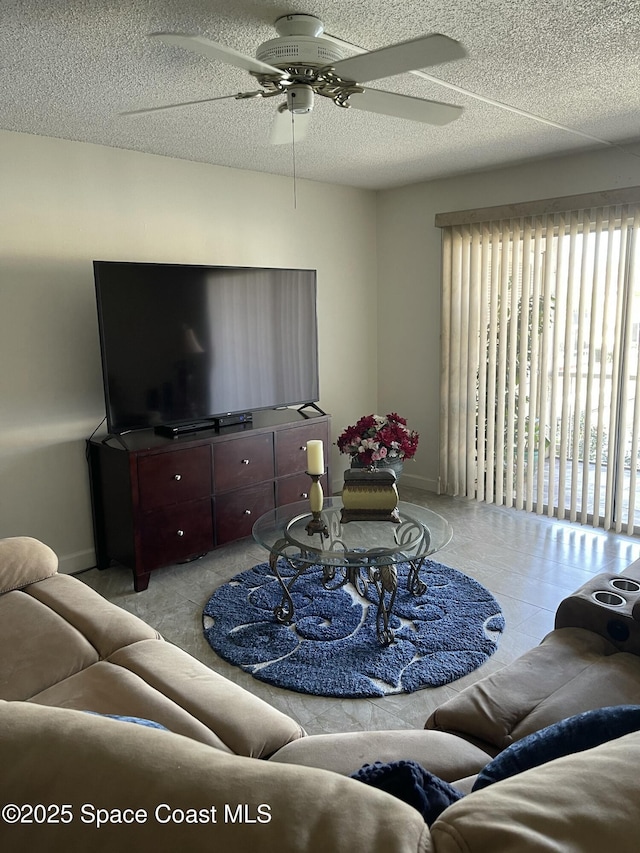 living room with ceiling fan, a healthy amount of sunlight, and a textured ceiling