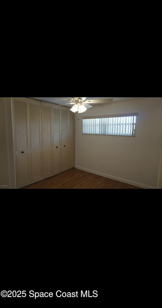 unfurnished bedroom featuring hardwood / wood-style flooring, ceiling fan, and a closet