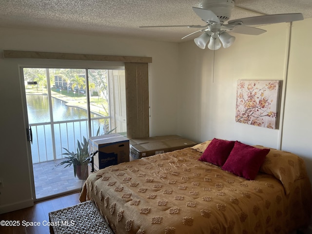 bedroom with ceiling fan, access to outside, a textured ceiling, and light hardwood / wood-style flooring