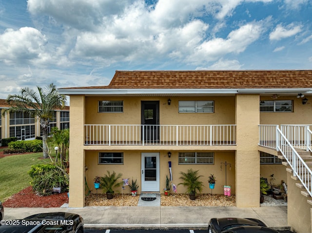 view of front facade featuring stucco siding and roof with shingles