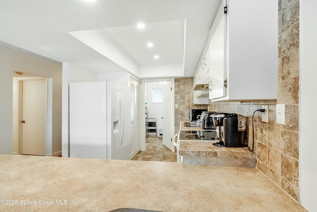 kitchen with light countertops, white cabinetry, a wood stove, white appliances, and recessed lighting