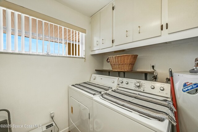 laundry room with water heater, cabinet space, and washer and dryer