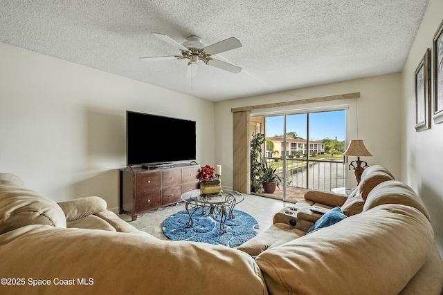 living area with a textured ceiling and ceiling fan