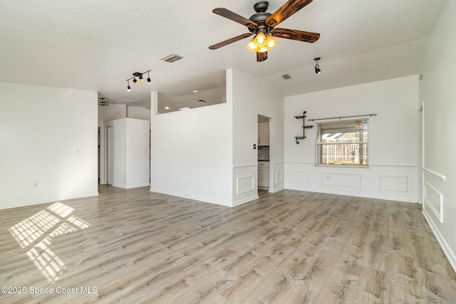 unfurnished living room featuring a textured ceiling, ceiling fan, and light wood-type flooring