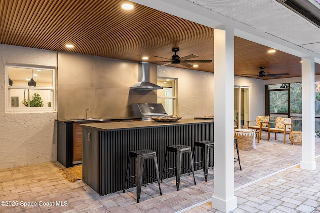 bar featuring wood ceiling, ceiling fan, island range hood, and sink