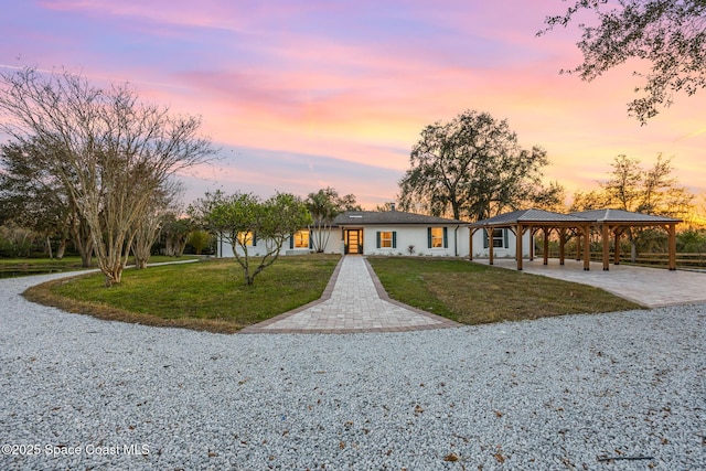 single story home featuring a carport and a lawn